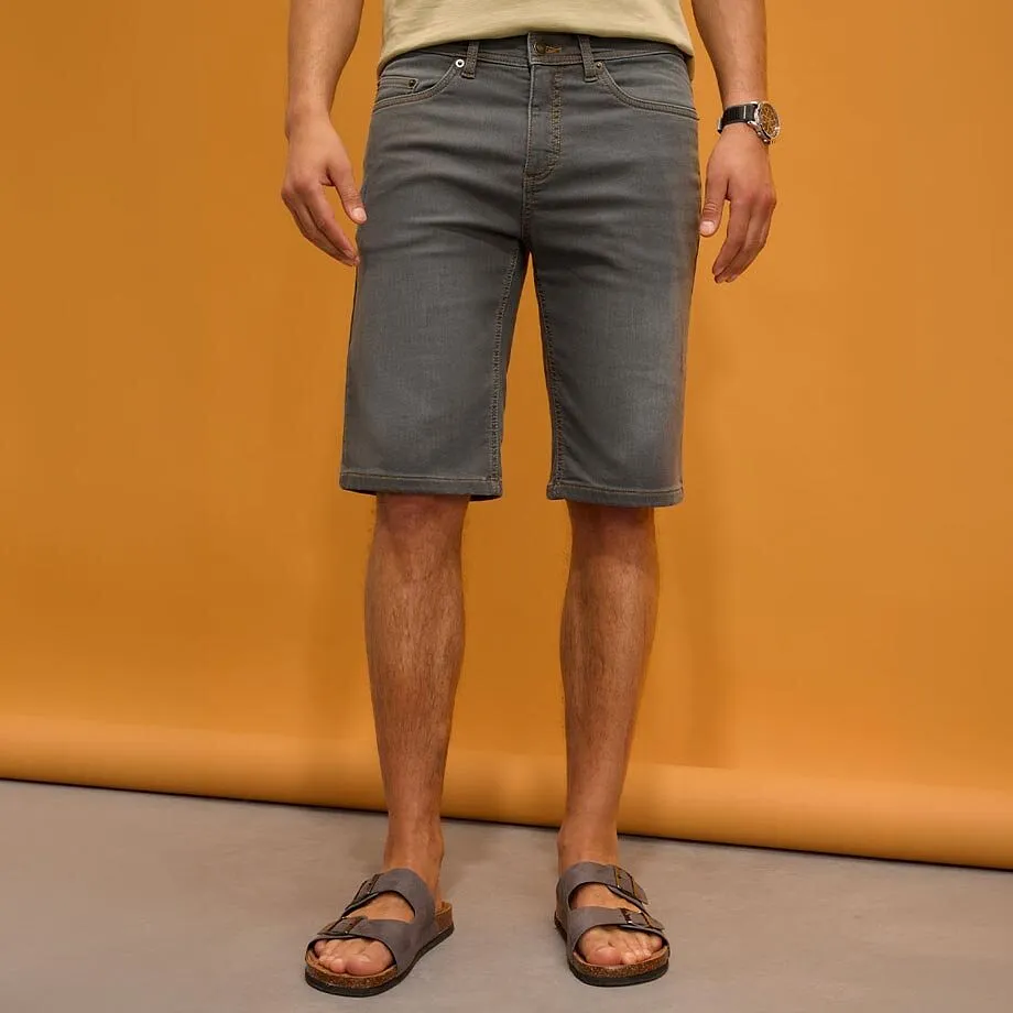 Gr&aring; shorts, ljus tr&ouml;ja och bekv&auml;ma tofflor.