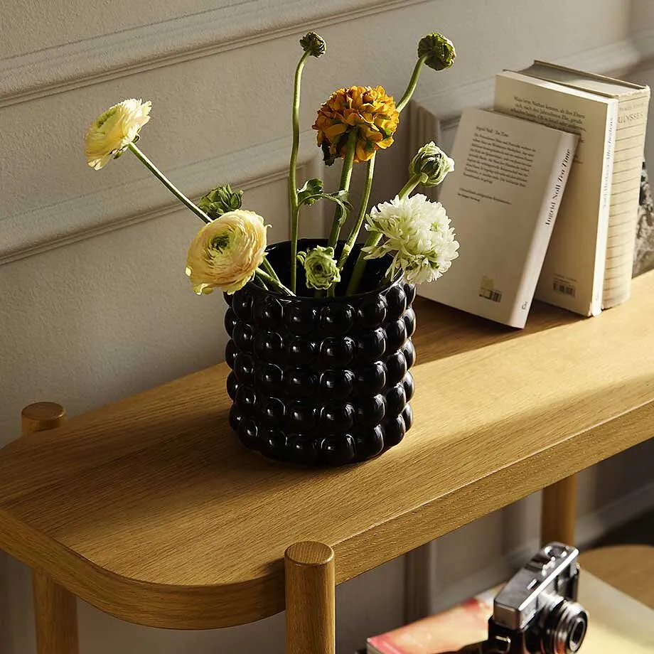 Blommor i en vas p&aring; ett tr&auml;bord.