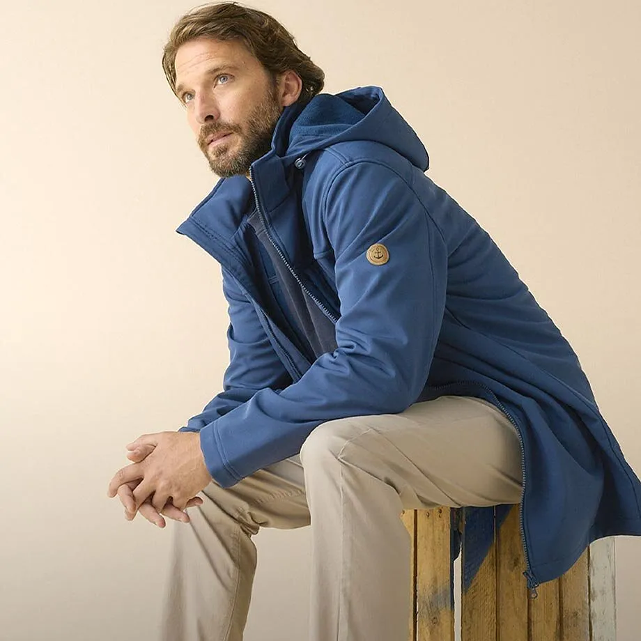 Bl&aring; parkas med huva, beige byxa och stils&auml;kra sneakers.
