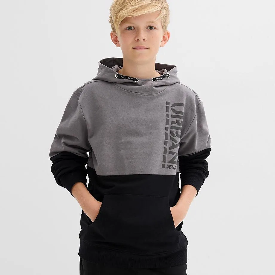 Tv&aring;f&auml;rgad hoodie i gr&aring;tt och svart med texten &rdquo;URBAN&rdquo;, tillsammans med svarta byxor.