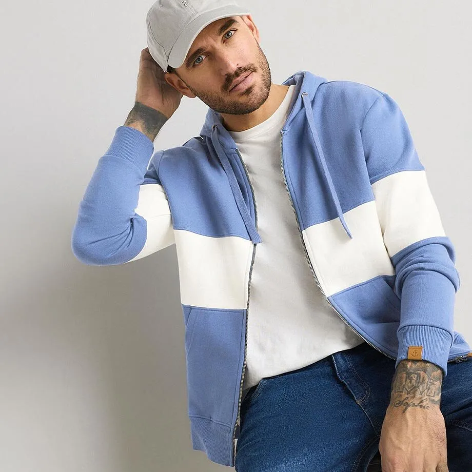 Ledig look: bl&aring; huvtr&ouml;ja, vit T-shirt, jeans och gr&aring; keps.