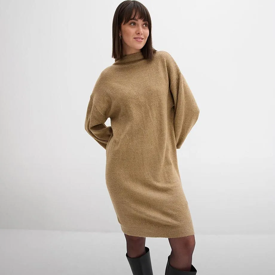 Mysig, kamelf&auml;rgad stickad kl&auml;nning kombinerad med svarta strumpbyxor och eleganta st&ouml;vlar.