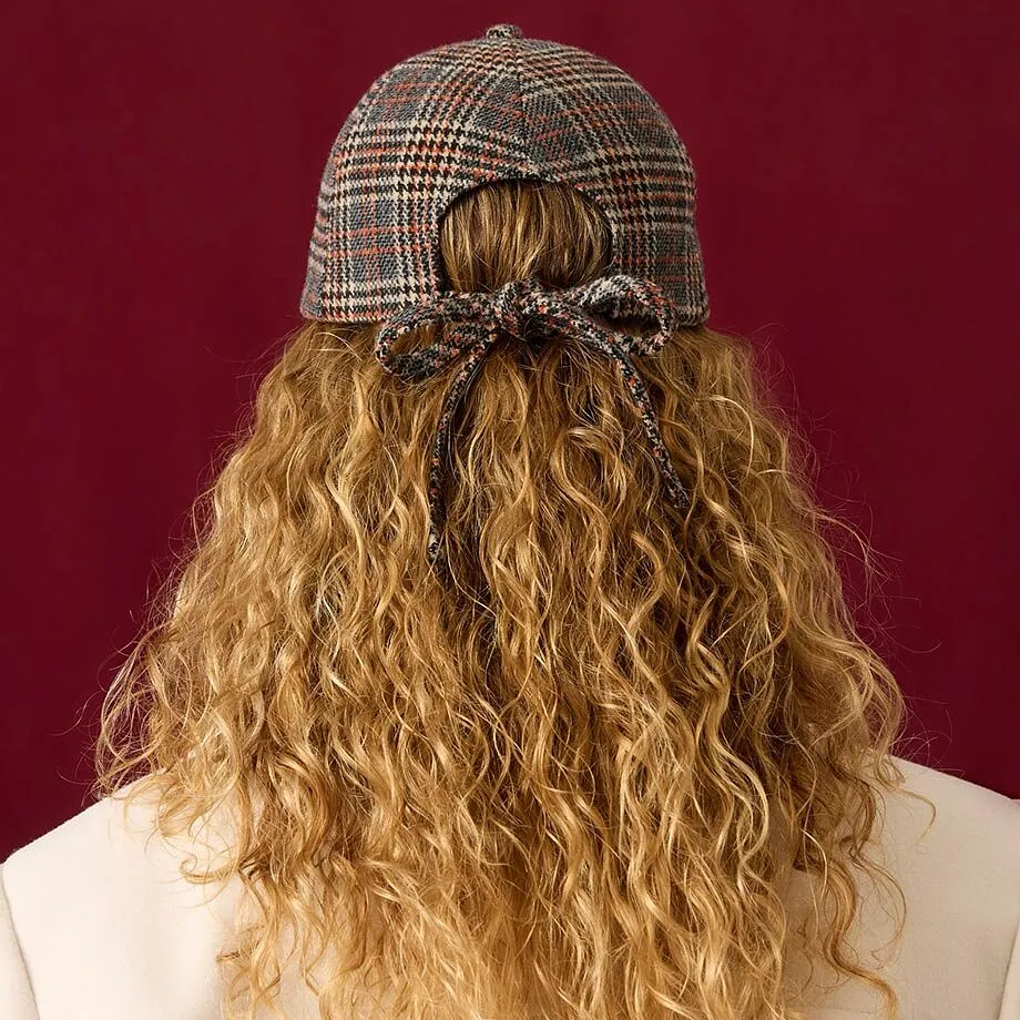 Rutig keps, cremef&auml;rgad kappa och brun, ribbstickad tr&ouml;ja f&ouml;r en stilfull look.