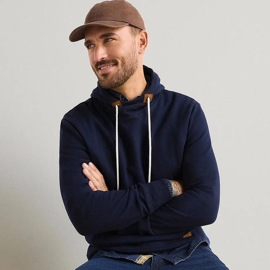 M&ouml;rkbl&aring; luvtr&ouml;ja, brun keps och jeans f&ouml;r en ledig look.