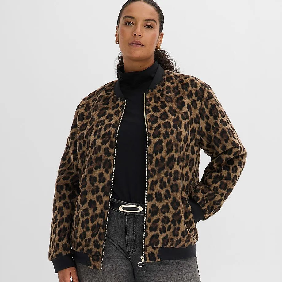 Leopardm&ouml;nstrad blusjacka &ouml;ver en svart polotr&ouml;ja, kombinerat med gr&aring; jeans och ett elegant sk&auml;rp.
