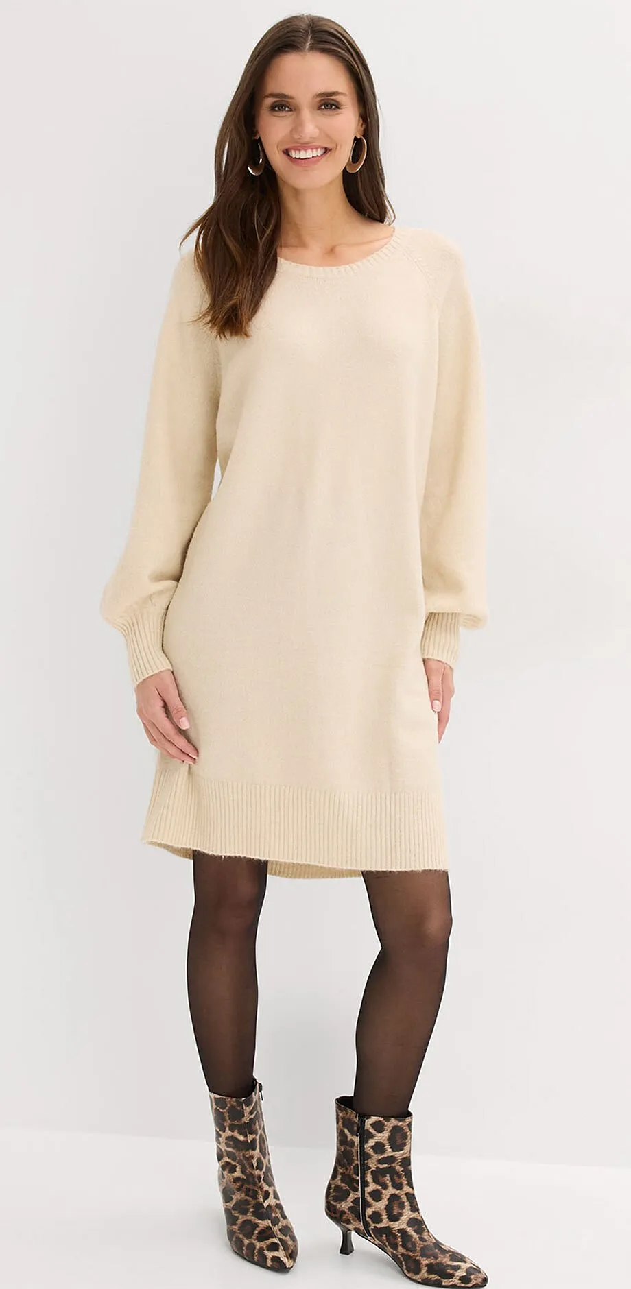 Naturf&auml;rgad stickad kl&auml;nning med l&aring;nga &auml;rmar.

