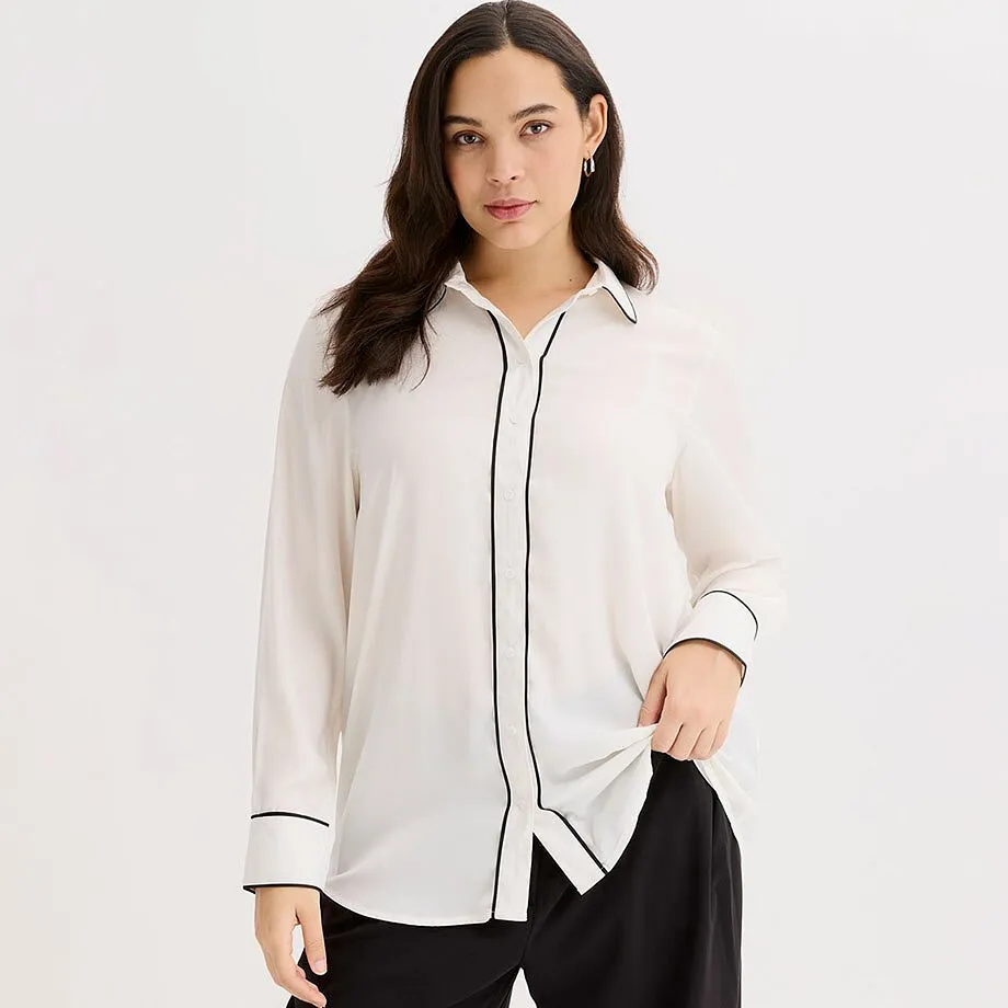 Vit blus med svart passpoal. Klassisk skjortkrage och l&aring;nga &auml;rmar.

