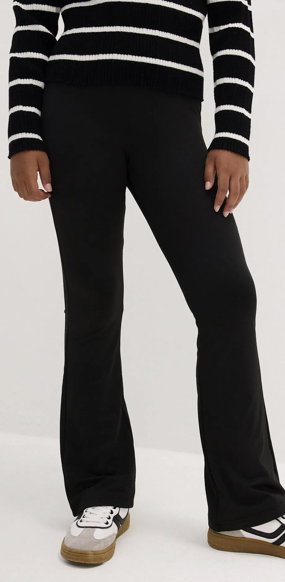 Svarta leggings med utsv&auml;ngda ben, till det vit-svarta sneakers och en randig tr&ouml;ja