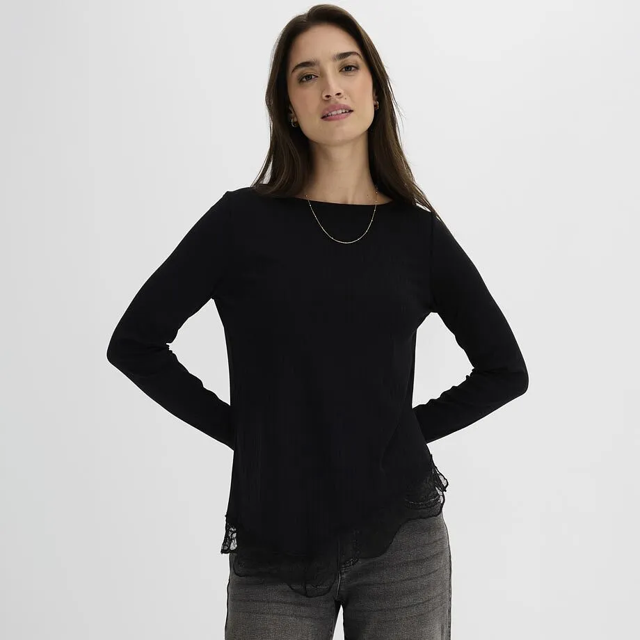 Svart, ribbad och l&aring;ng&auml;rmad topp med elegant spetsbes&auml;ttning, kombinerad med lediga, gr&aring;a jeans.
