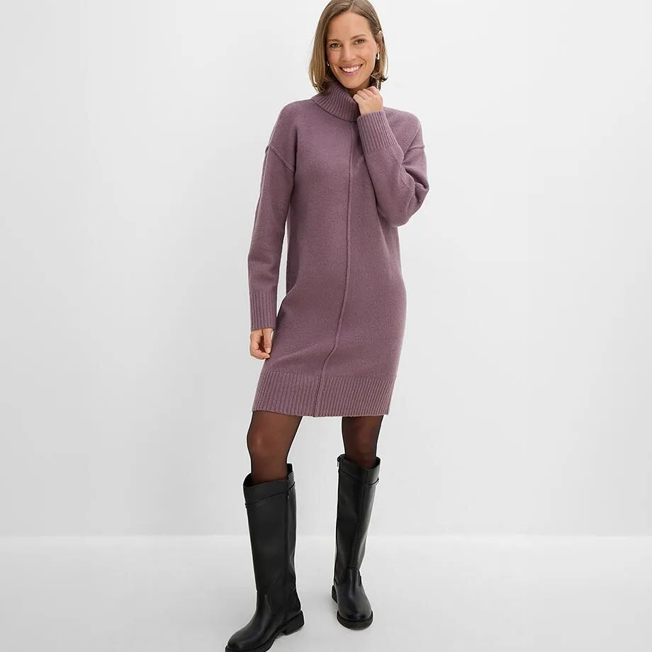 Elegant, lila stickad kl&auml;nning med polokrage, till det svarta strumpbyxor och h&ouml;ga st&ouml;vlar.