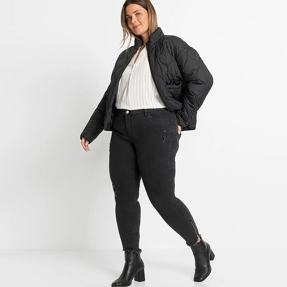 Svart t&auml;ckjacka, randig blus, jeans med dragkedjor och lediga st&ouml;vletter.