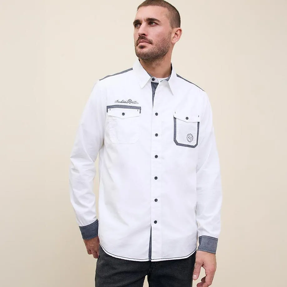 En vit skjorta med knappar och br&ouml;stfickor.

