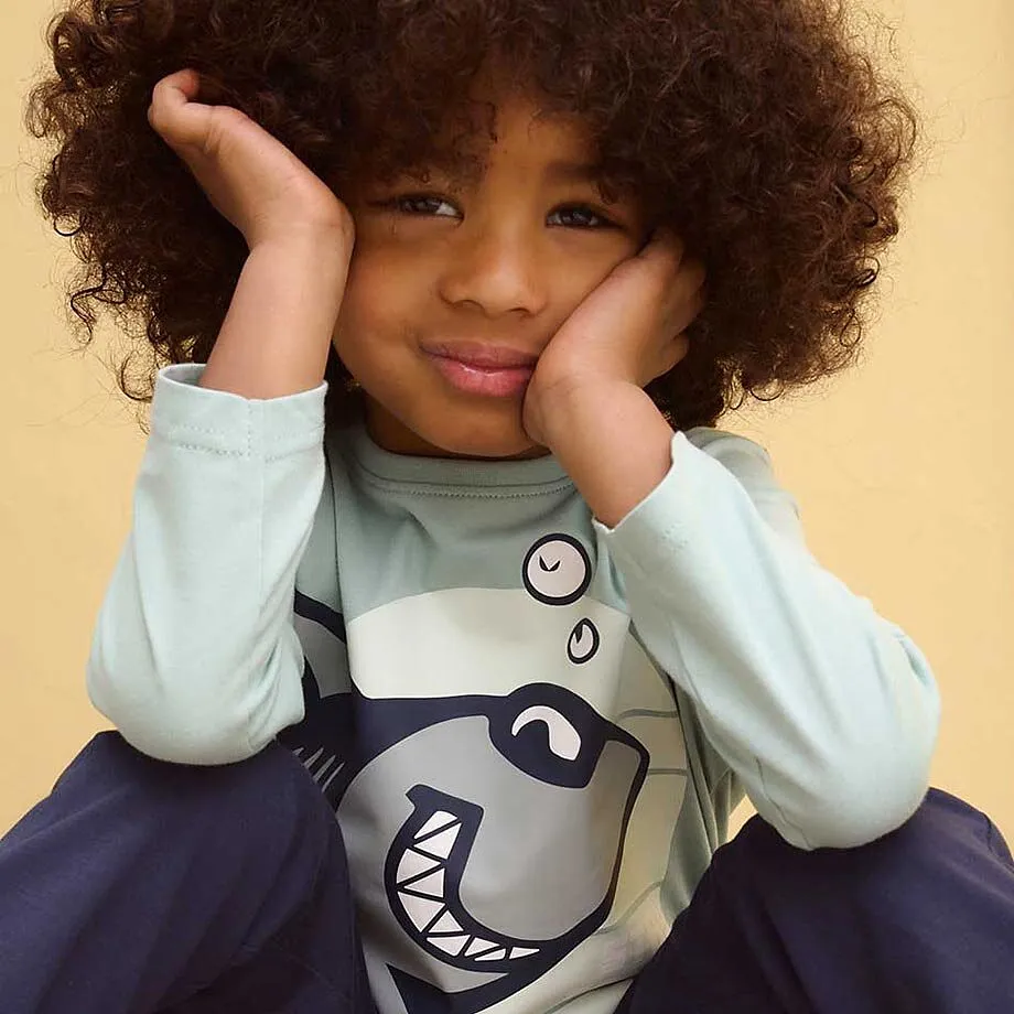 Tr&ouml;ja med hajm&ouml;nster, kombinerad med m&ouml;rka byxor.