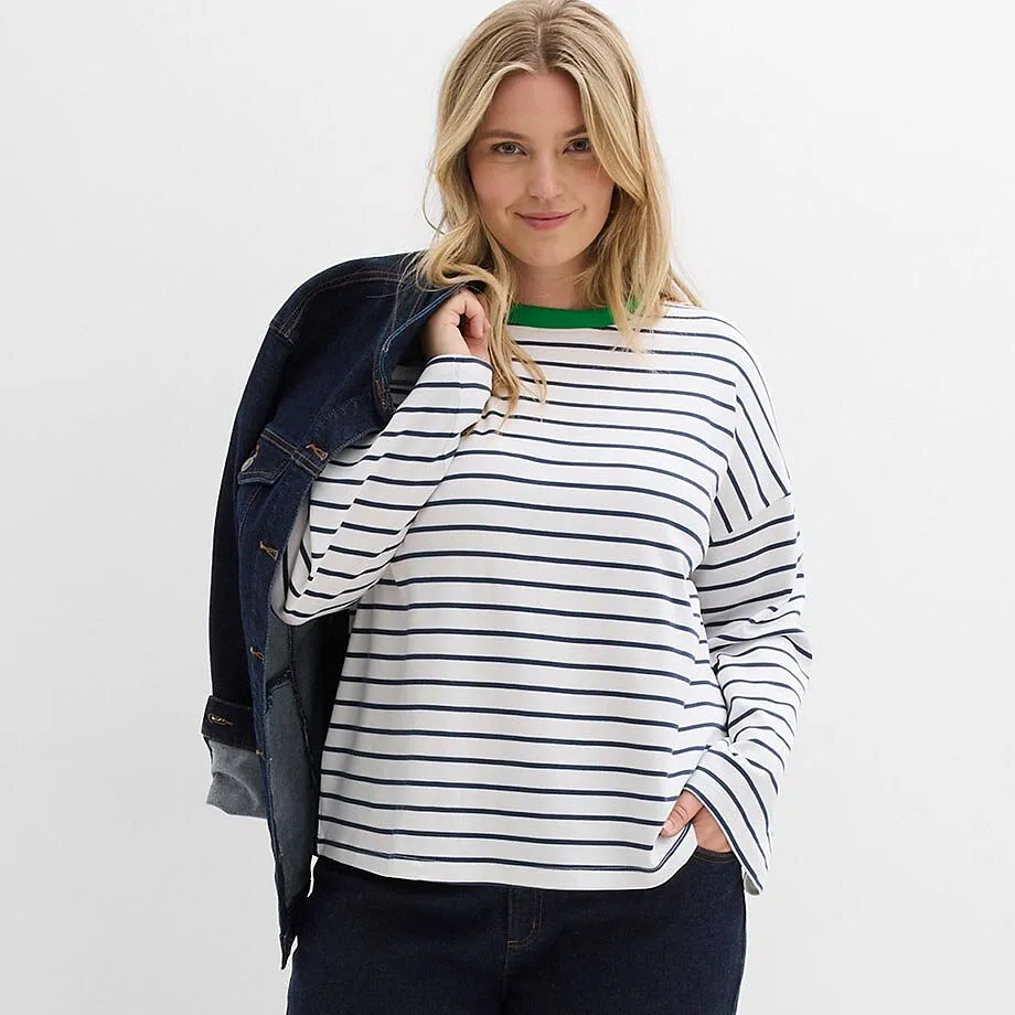 Randig tr&ouml;ja med gr&ouml;n halsringning, m&ouml;rkbl&aring; jeansjacka sl&auml;ngd &ouml;ver axeln.

