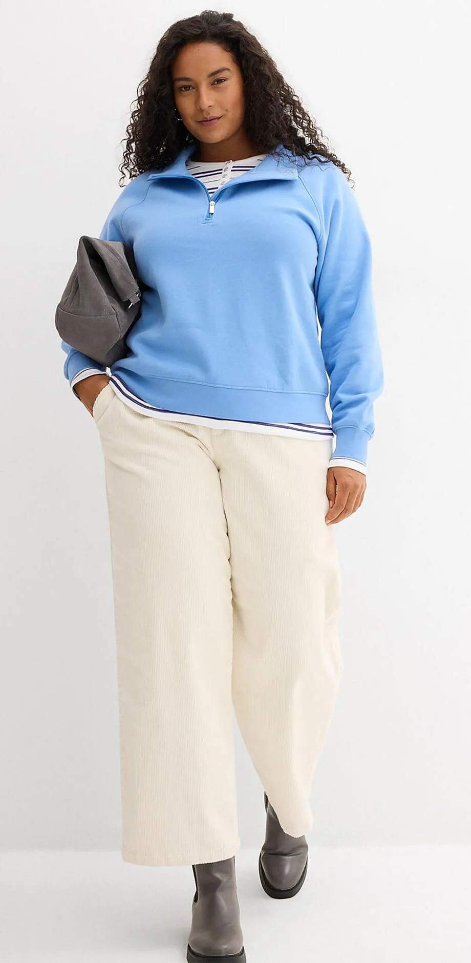 Ljusbl&aring; tr&ouml;ja och vida cremef&auml;rgade byxor.

