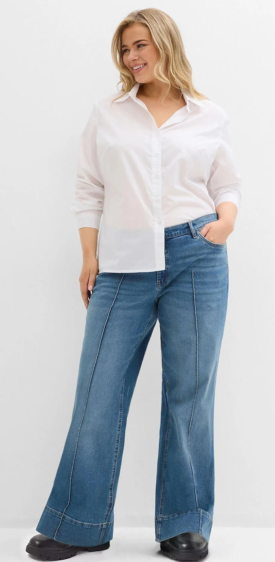 Vit skjorta kombinerat med vida jeans och svarta skor.

