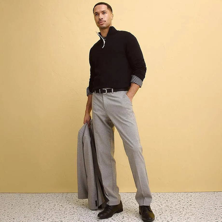 M&ouml;rk &ouml;verdel med krage, gr&aring; kostymbyxor och kavaj.