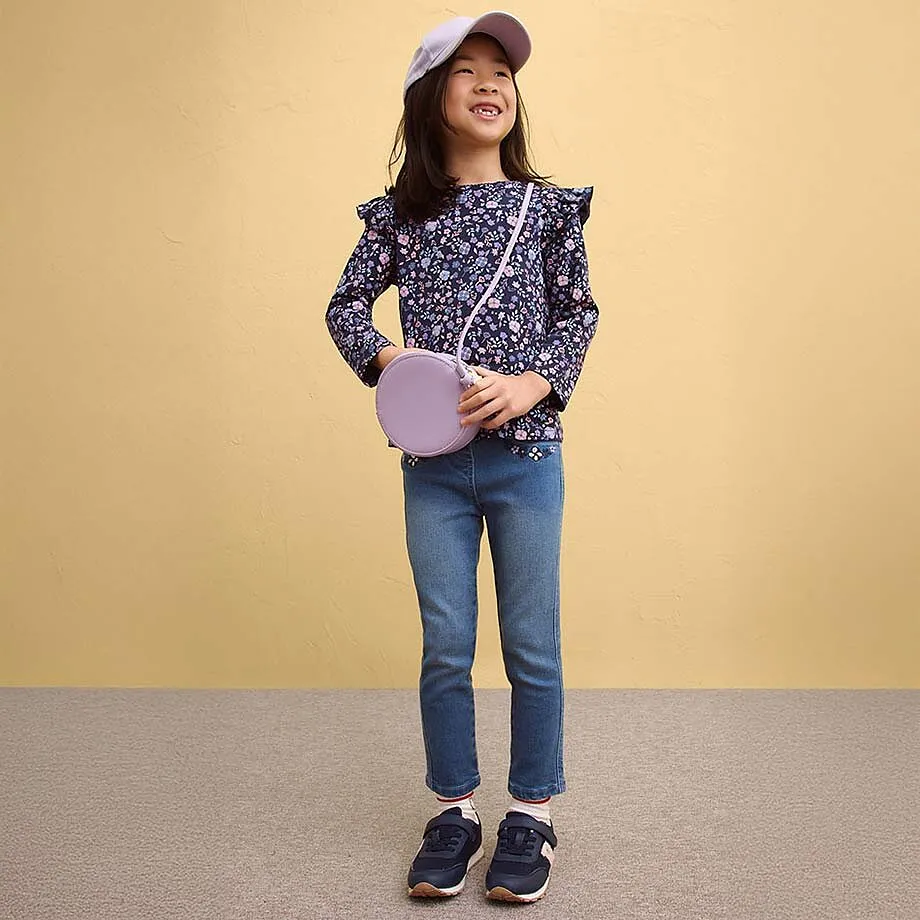 Blommig topp med volanger, till det jeans och sneakers.

