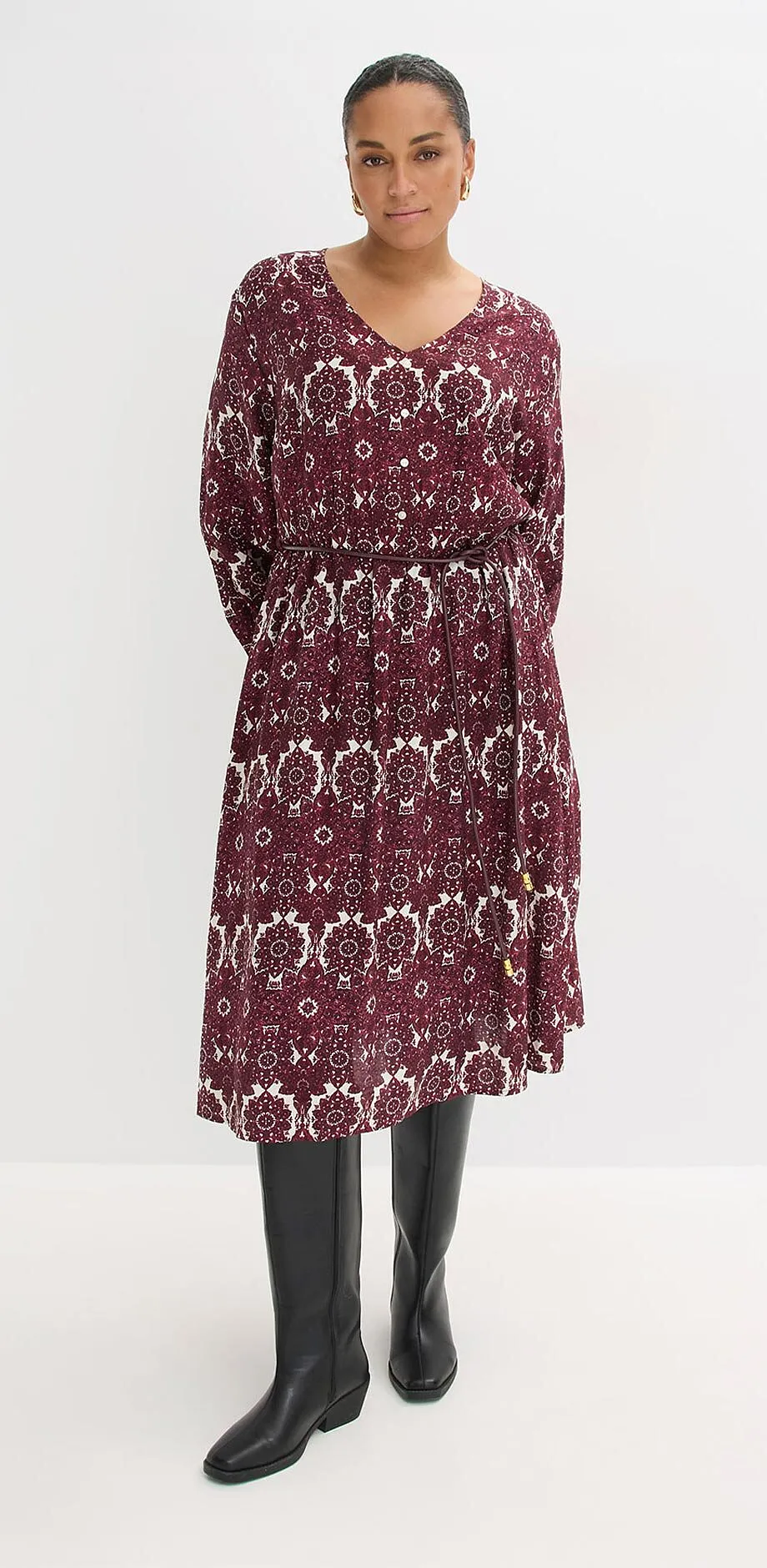 Kl&auml;nning med blomm&ouml;nster i bordeaux och vitt. L&aring;nga &auml;rmar, V-ringning och midi-l&auml;ngd.