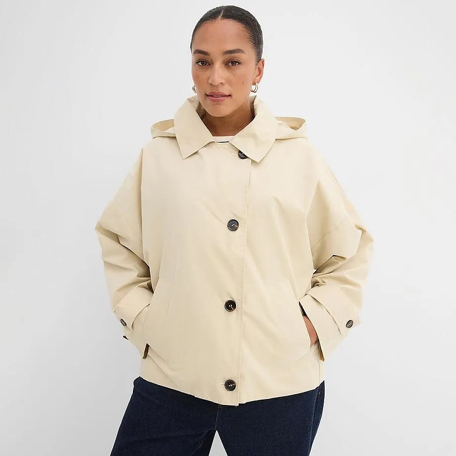 Cremef&auml;rgad jacka med knappar och krage.

