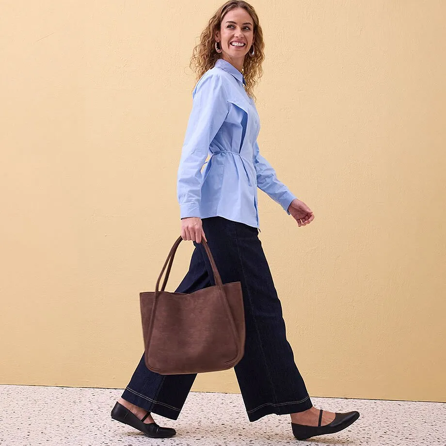 Ljus blus, vida m&ouml;rka byxor och ballerinaskor.

