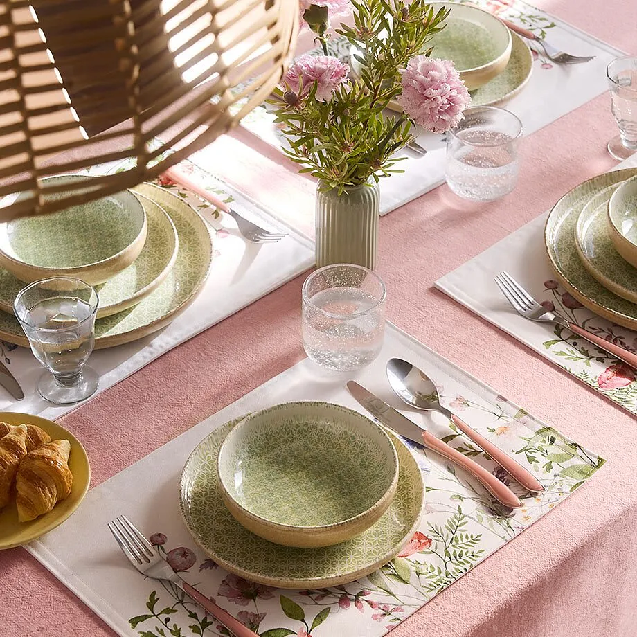 Duk i rosa pryder det dukade bordet.

